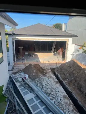 ADU garage conversion - beginning the construction process by digging a ditch for utilities