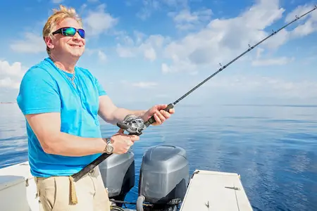 senior fishing with pole from boat in Southern Florida